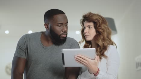 young couple choosing photo at living room together.