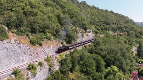 un tren de vapor se mueve hacia la cámara, seguido por un avión no tripulado que rastrea la locomotora, martel, lot, francia