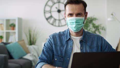 portrait of man working at home in protective mask