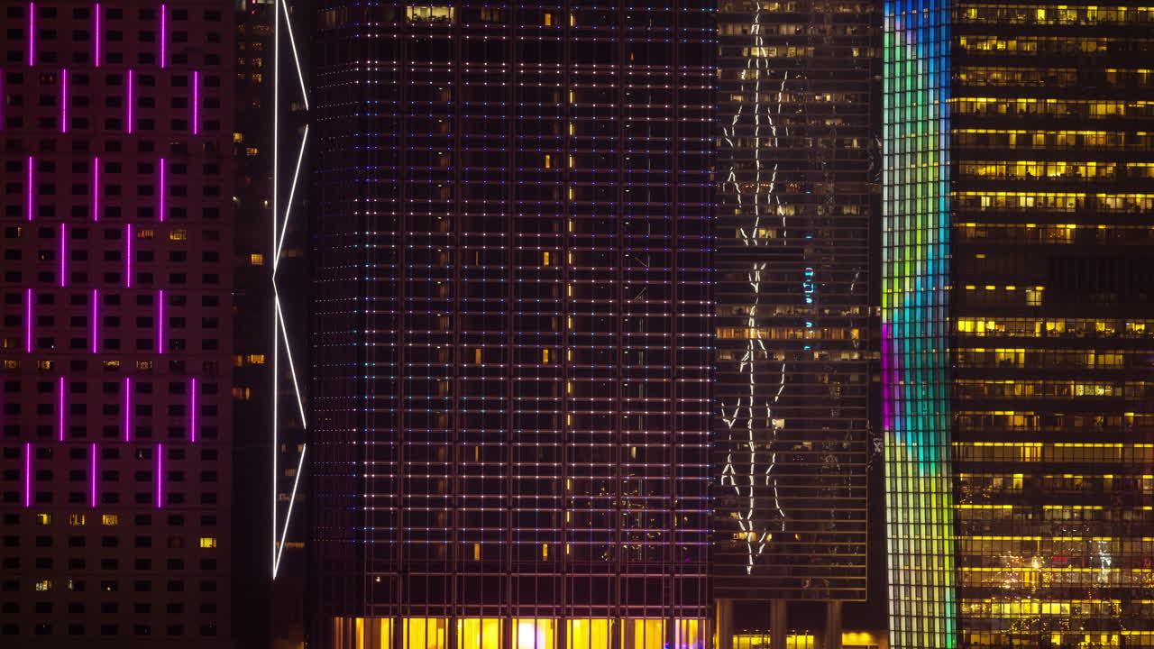 HONG KONG - 19 MARCH 2025 : Hong Kong Central city skyline filmed from across the harbour in kowloon with all the skyscrapers lit up at night advertisements