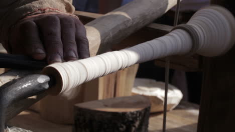 craftsman turning wood on a vintage lathe