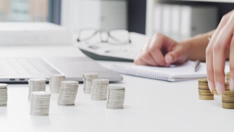 woman organizing stacks of coins on a desk