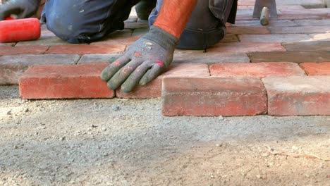 paver lay down stone pavers and adjusts level with pavers mallet