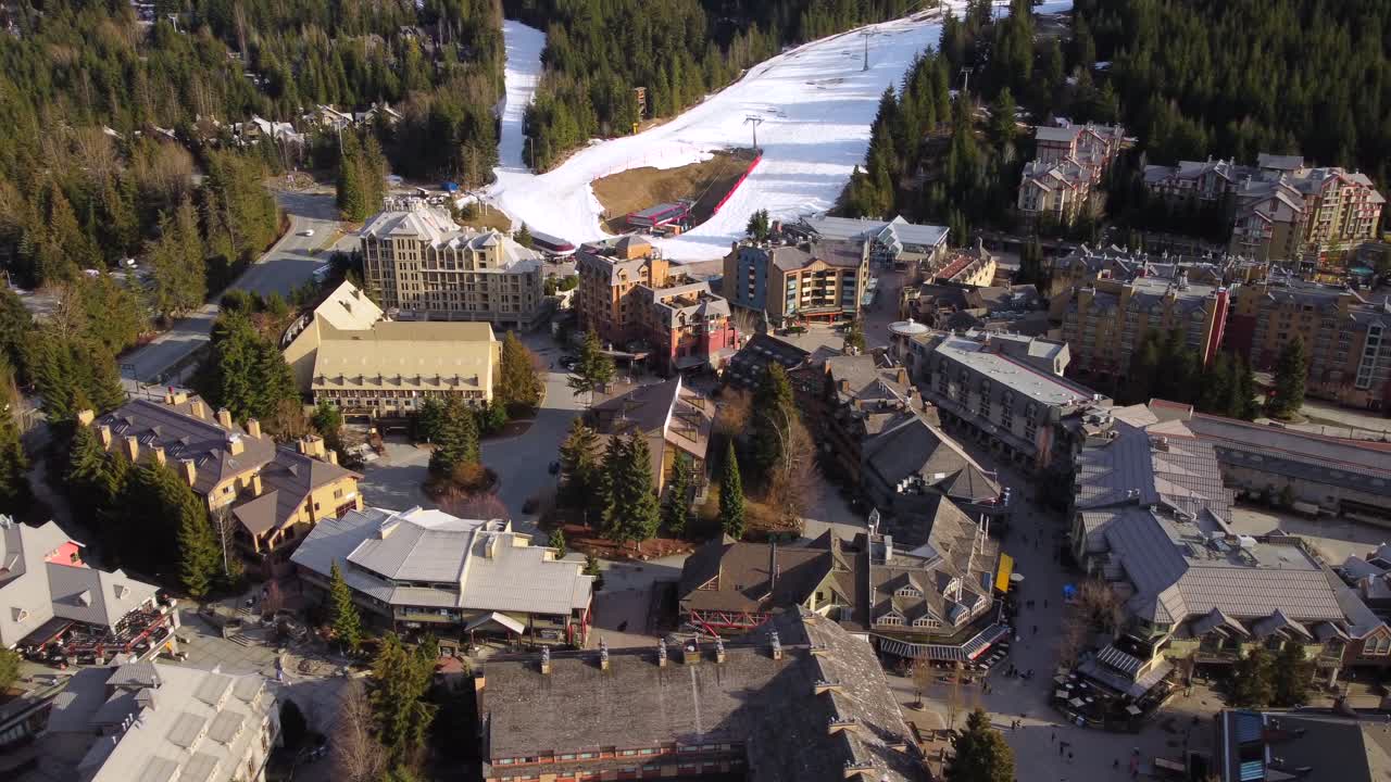 Golden Hour Aerial of Whistler resort town with a ski run in the background