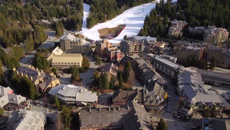 golden hour aerial of whistler resort town with a ski run in the background