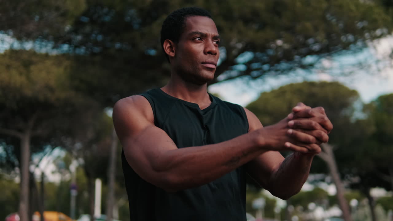 Muscular Black Man Stretching in the Park