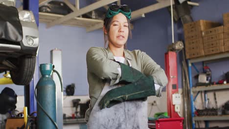 Video-of-biracial-female-car-mechanic-posing-at-camera