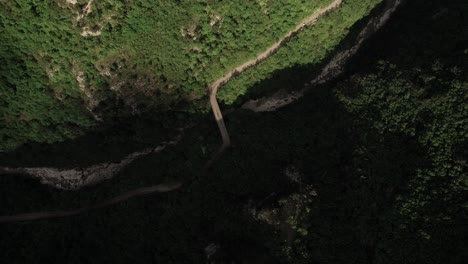 Vista-Aérea-Inclinada-Hacia-Abajo-De-Un-Pequeño-Camino-En-Desarrollo-En-Las-Montañas