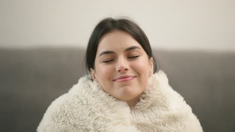 young beautiful woman in warm blanket at home