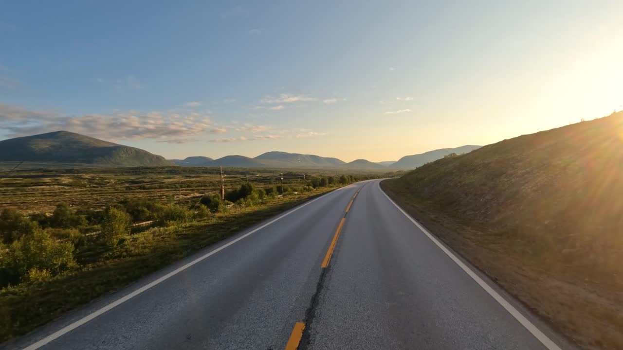 Driving a Car on a Road in Norway at dawn.