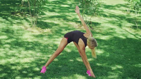 Fitness-woman-training-stretching-exercise-while-workout-in-green-park