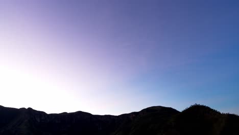 stunning timelapse of sunrise revealing mountain silhouettes as the sky transitions from black to colorful and clear blue