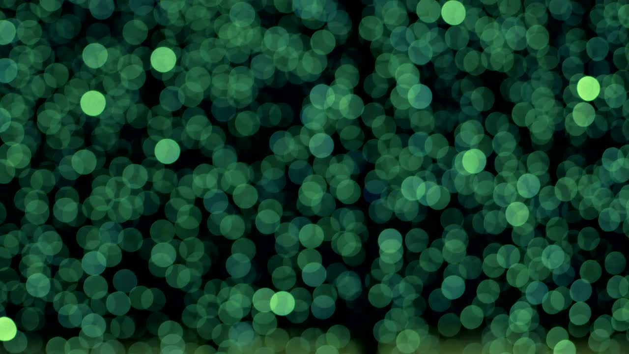 Night abstract green background is defocused with nice bokeh. Blurred Christmas Lights Bokeh. Pan across blur .