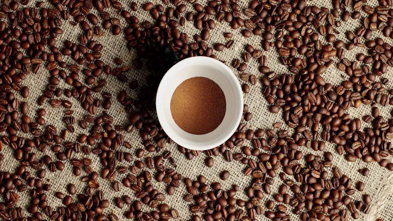Kaffebønner og en kop pulver