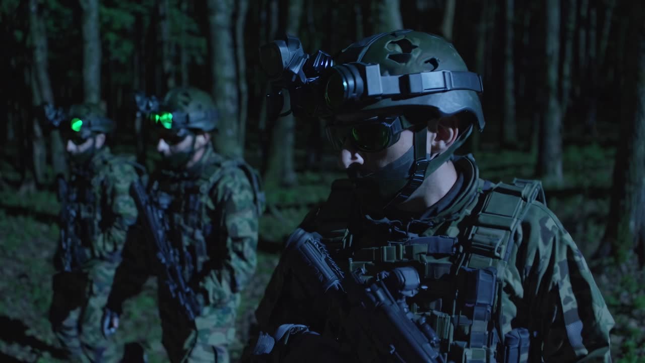 Night vision video scene of soldiers in a forest, captured from a low-angle, highlighting tactical
