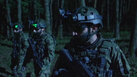 night vision video scene of soldiers in a forest, captured from a low-angle, highlighting tactical