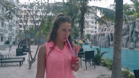 young lady walks around hotel yard near swimming pool