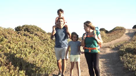 pareja de padres activos e hijos caminando por el camino