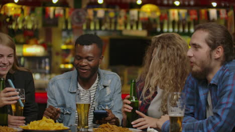 Group-Of-Young-Friends-Drinking-And-Laughing-In-A-Bar