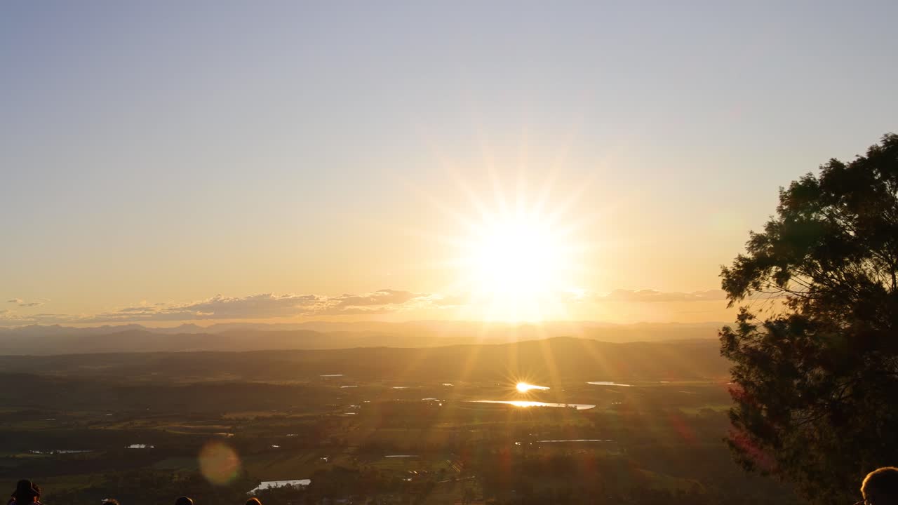 People gather to watch a stunning sunset over plains