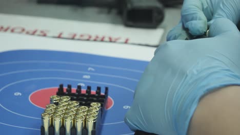 alimentación manual de balas de 9 mm en el cargador de pistola para arma de campo de tiro