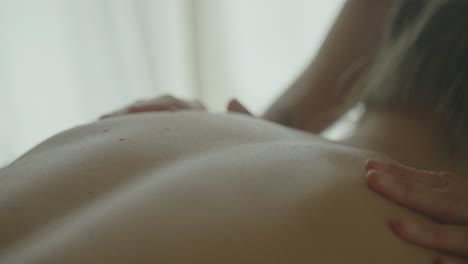 a relaxing massage session with soft light and gentle hands on a person's back, close-up