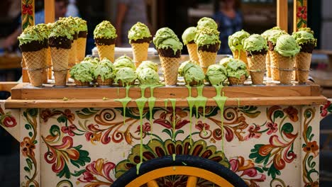 an abundant display of vibrantly colored ice cream cones with melting toppings on a decorative cart, showcasing the delightful treats perfect for warm days