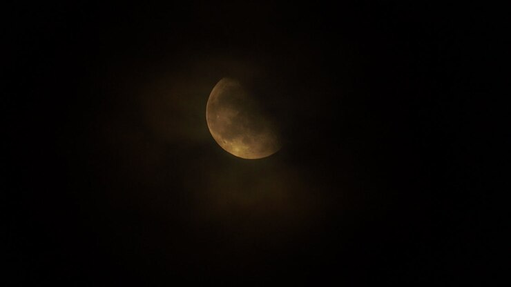 Clouds slowly passing in front of a bright moon at night
