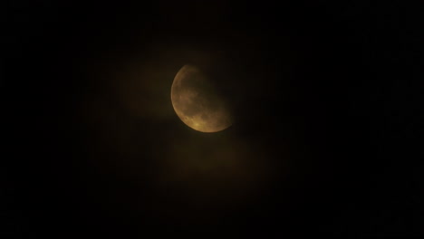 Clouds-slowly-passing-in-front-of-a-bright-moon-at-night