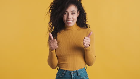 una mujer afroamericana feliz sobre un fondo naranja.