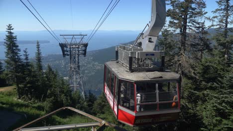 Grouse-Mountain-Skyride---Aerial-Tram-Leaving-Passenger-Gate-With-View-Of-Mountaintop-Chalet-And-Lodge