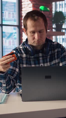 vertical video man doing internet shopping, carefully typing credit card information