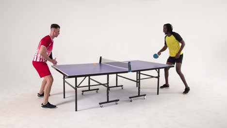 multiracial male table tennis players serving and passing the ball to each other on white background