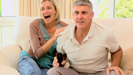 couple excitedly watching sports on tv