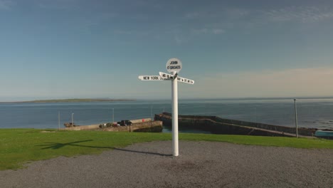 john o'groats harbour and famous signpost landmark on a summers day