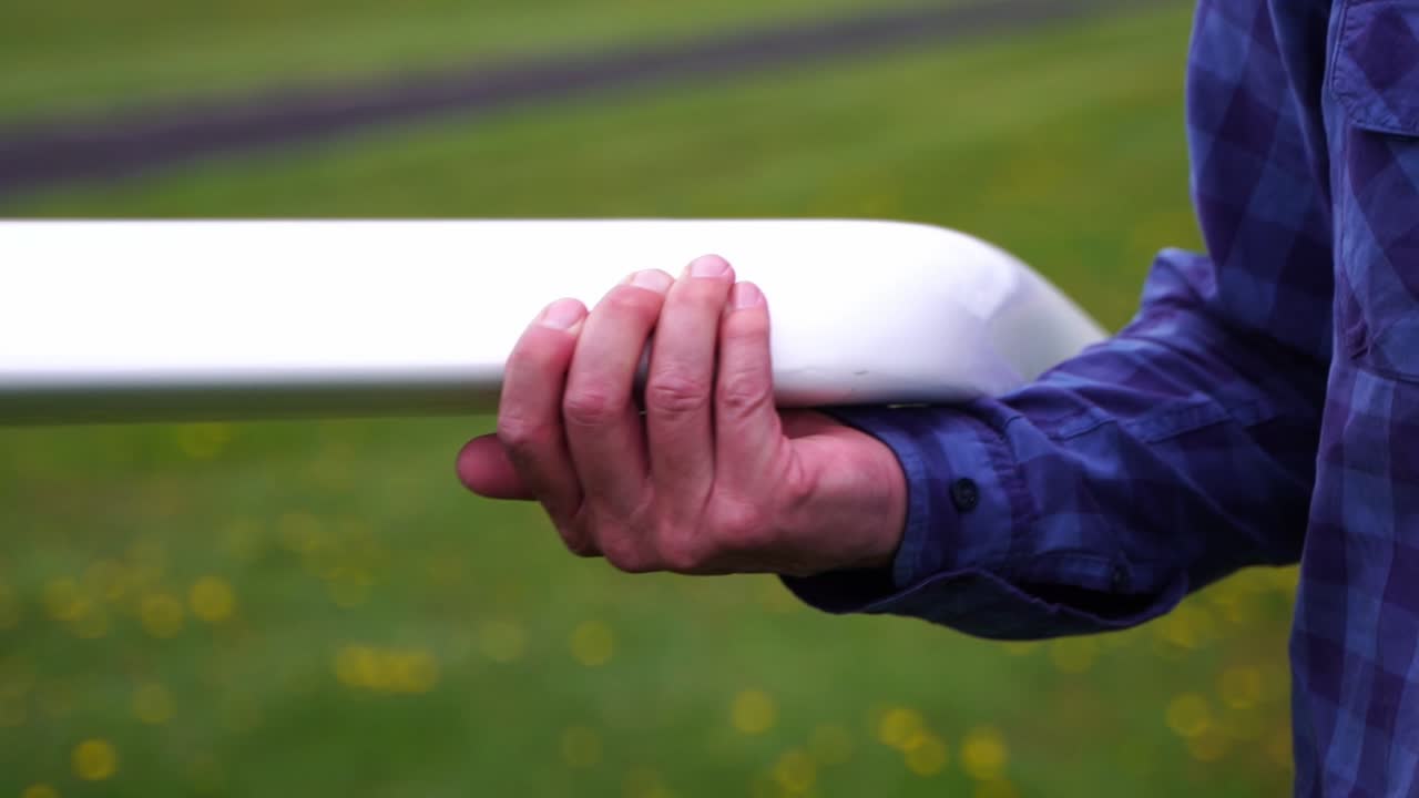 hand holding and wearing wing of a small airplane