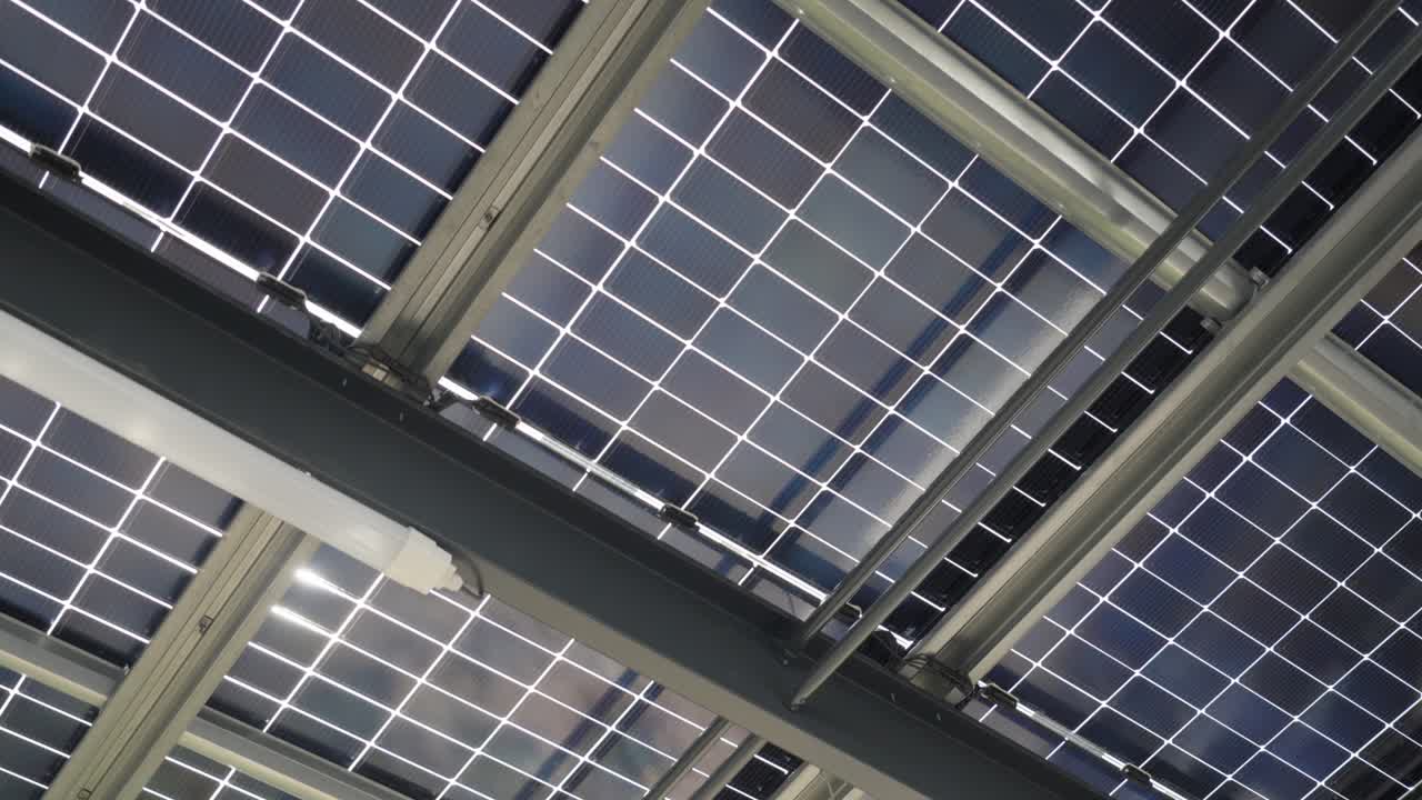 revealing shot of a large solar panel collection ontop of a buildings roof