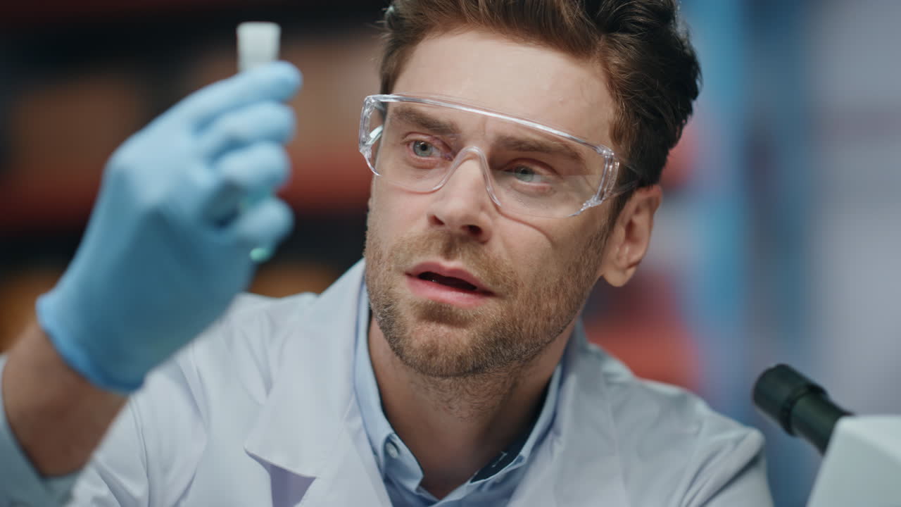 un investigador de laboratorio triste analizando un experimento insatisfecho en un tubo de ensayo de cerca.