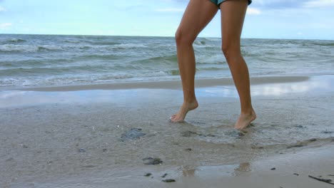 a woman playing alone with at the ocean in summertime