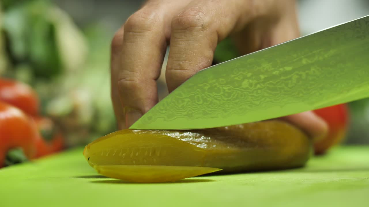 날카로운 다마스쿠스 강철 칼로 절인 오이를 자르고, 클로즈업