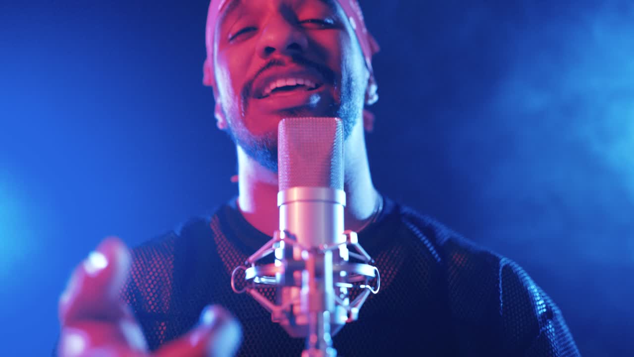 Rapper singing and performing on a stage with blue lights
