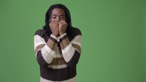 young handsome african man with dreadlocks against green background