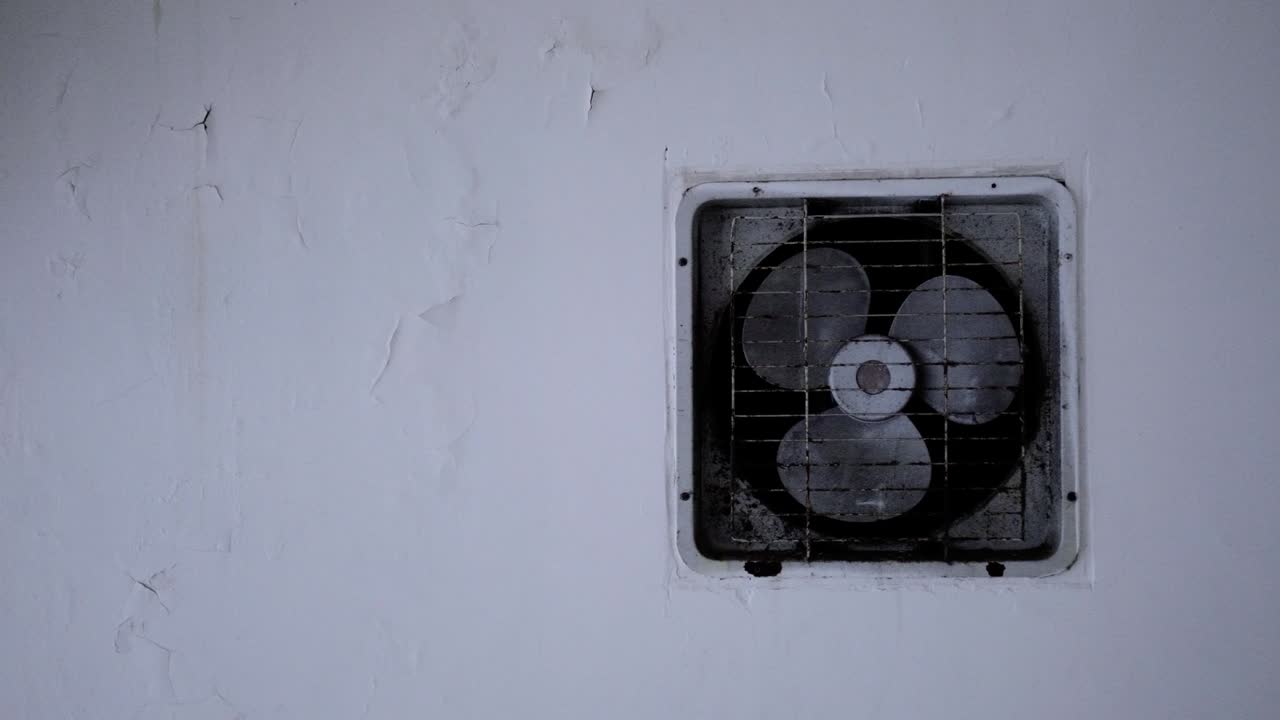 The old exhaust fan is on the wall of the apartment.