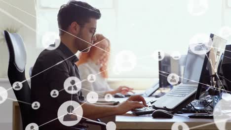 animación de la red de iconos de perfil contra el hombre caucásico usando la computadora en la oficina.