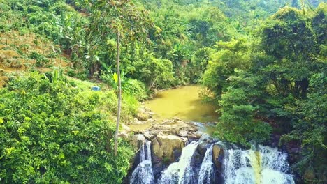 motion down along waterfall and palm trees to lake