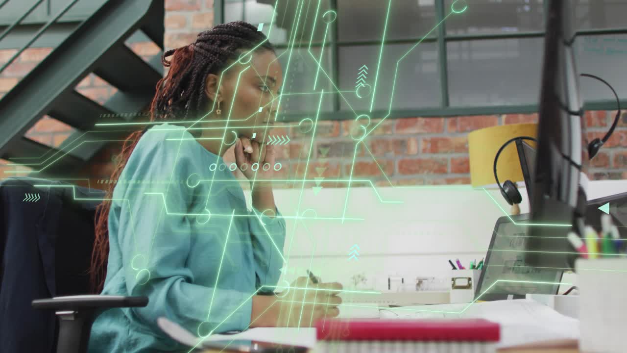 Woman writing at desk in tech office, activating circuit graphics analyzing data and nibbling apple