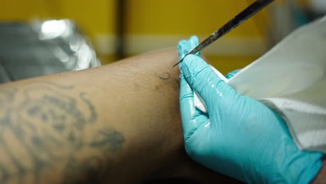 close-up of a person receiving a tattoo on their leg