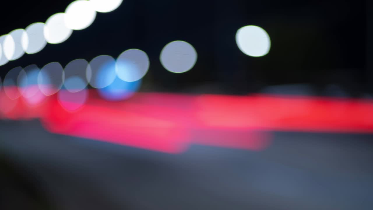 tiempo de lapso de los semáforos nocturnos en la ciudad. hermoso bokeh en el fondo oscuro borroso por la noche. uhd, 4k