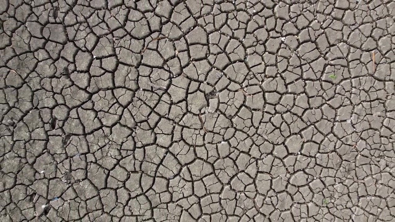 An aerial view of a dried and cracked lake bed exposed by heat wave and drought conditions.