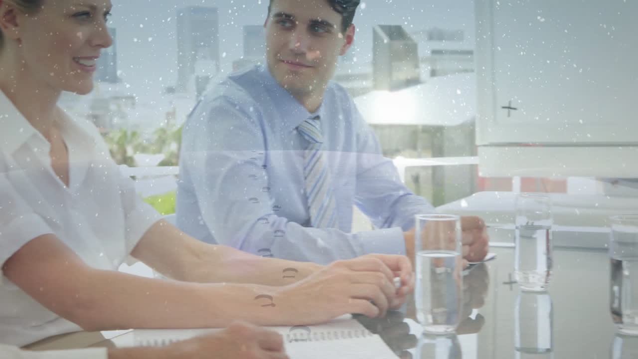 Meeting in office, diverse professionals discussing with snowflake animation overlay